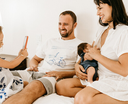 Happy family on bed laughing with their children