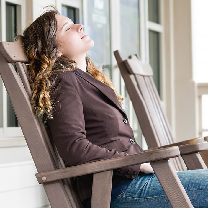 Young woman relaxing on a chair outdoor on a porch