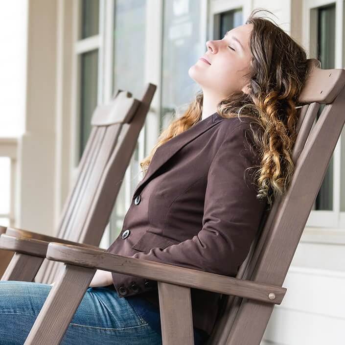 Young woman relaxing on a chair outdoor on a porch
