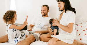Happy family on bed laughing with their children