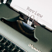 Typewriter showing a piece of paper with the typed word "review"
